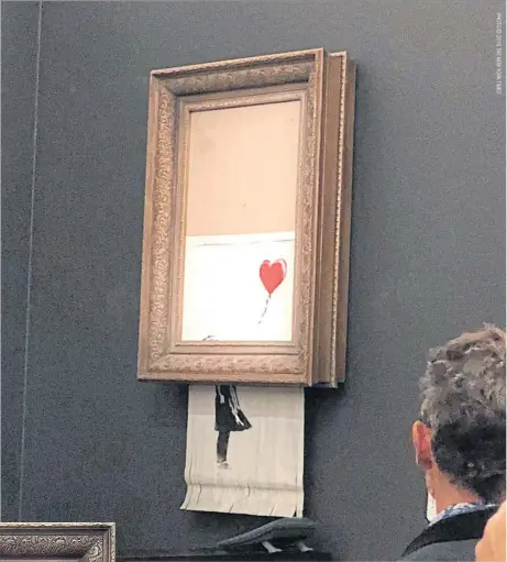  ??  ?? The moment when Banksy’s Girl With Balloon was destroyed by a remote-control shredder, at Sotheby’s, London.