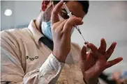  ?? Associated Press file photo ?? A medical worker prepares a COVID-19 shot in Jerusalem in September. Israeli leaders have said they would offer a fourth round of vaccines to some.