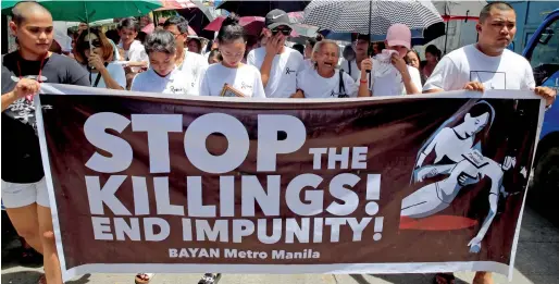  ?? Reuters ?? Relatives and loved ones of Leover Miranda, a drug-related killings victim, hold a streamer during a funeral march at the north cemetery in metro Manila on Sunday. —