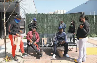  ?? Lea Suzuki / The Chronicle ?? Nic Lee (left), project manager for the Rafiki Coalition for Health and Wellness, and community outreach ambassador Angell Wells (right) talk to Vincent Talley (seated left) and Rico Tiger.