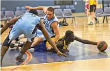  ??  ?? Manylok Malek (gold) scraps for the loose ball against the Toowoomba Saints.