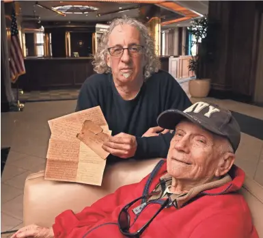  ?? MICHAEL SEARS / MILWAUKEE JOURNAL SENTINEL ?? Steve Cohen (rear) holds a letter from his uncle, Al Cohen, who as a soldier rolled into the Buchenwald death camp in Nazi Germany just days after liberation. Al Cohen wrote to his mother in Milwaukee and described what he saw there. The letter was found among the possession­s of Al Cohen's brother Neil Cohen (foreground).