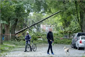  ?? ANDREW VAUGHAN — THE CANADIAN PRESS VIA AP ?? A street is blocked by fallen trees as a result of Hurricane Dorian pounding the area with heavy rain and wind Sunday in Halifax, Nova Scotia. Hurricane Dorian brought wind, rain and heavy seas that knocked out power across the region, left damage to buildings and trees as well as disruption to transporta­tion.