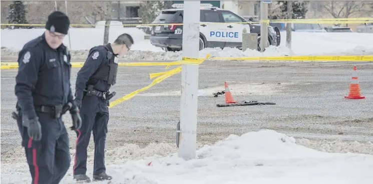  ?? SHAUGHN BUTTS ?? Police look for evidence near the scene of a shooting in Clareview, where an officer shot an armed man. The man was taken to hospital with gunshot wounds.