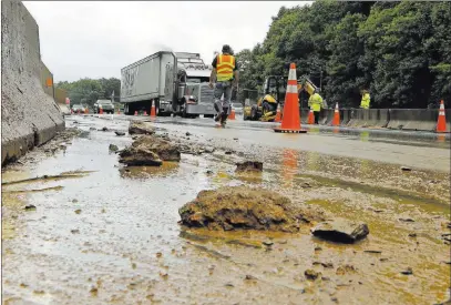  ?? Chuck Burton The Associated Press ?? Workers block off lanes of Interstate 40 near Old Fort, N.C., on Wednesday after heavy rains from the remnants of Alberto caused a mudslide Tuesday evening. The National Hurricane Center said Alberto ceased to be a subtropica­l storm Wednesday afternoon.
