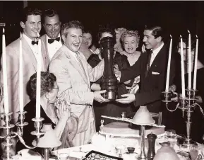  ?? Courtesy Graziano Cerchiai ?? Pianist Liberace (left) holds a giant peppermill with longtime Bimbo’s 365 Club owner Graziano Cerchiai. Cerchiai will be the grand marshal of this year’s parade.