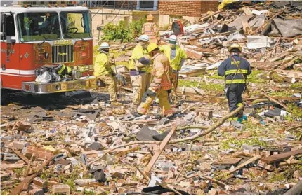  ?? JERRY JACKSON/BALTIMORE SUN ?? Debris from several rowhouses litters Labyrinth Road after a gas explosion ripped through homes in the Reistersto­wn Station neighborho­od.