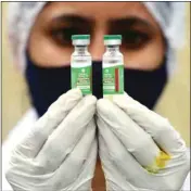  ?? PIC/PTI ?? A medic shows vial containing doses of Covishield vaccine at a government health care centre, in New Delhi