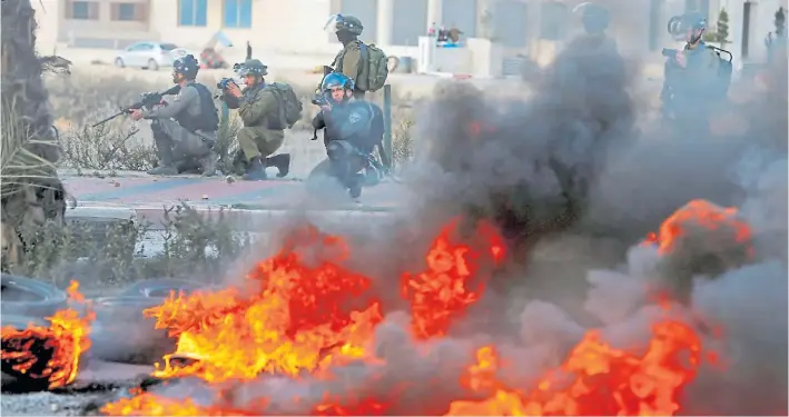  ?? AFP ?? Enfrentami­entos. Tropas israelíes en una calle de Ramallah durante los choques con manifestan­tes palestinos que reclaman contra la decisión del jefe de Estado norteameri­cano.