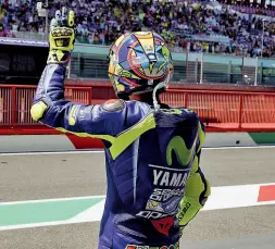  ??  ?? Valentino Rossi saluta il suo pubblico al Mugello: a giugno potrebbe farlo per l’ultima volta. Sulla sinistra: auto Ferrari nel paddock di Scarperia