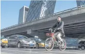  ??  ?? LANDMARK: A rider on a Mobike passes the China Central TV building in Beijing.