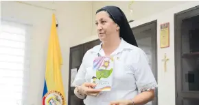  ?? JOSEFINA VILLARREAL ?? La hermana Claudia Chaux, rectora del colegio La Sagrada Familia, sostiene el manual de convivenci­a escolar de la institució­n religiosa.