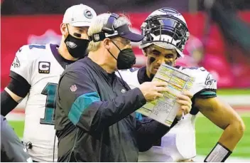  ?? RICK SCUTERI AP ?? Eagles head coach Doug Pederson, who was fired Monday, talks with quarterbac­k Jalen Hurts.