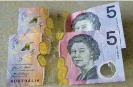  ?? MARK BAKER/AP 2022 ?? Australian $5 notes feature an image of the late Queen Elizabeth II, but new bills will not have King Charles III on them, the nation’s central bank said last week.