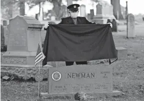  ?? [KYLE ROBERTSON/DISPATCH] ?? Steve Cox unveils the headstone obtained for fellow Columbus firefighte­r Mark B. Newman during a ceremony at Green Lawn Cemetery on Tuesday, the 150th anniversar­y of his on-duty death. Research located his unmarked grave, and a fundraisin­g effort paid for the headstone.