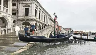  ?? —aP ?? Out of place: a gondola boat stranded atop a bike rack after the high tide in venice.