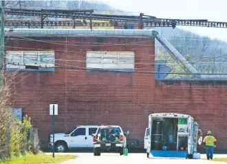  ?? STAFF PHOTO BY ERIN O. SMITH ?? An SRT Safety team works along a blocked-off portion of Williams and Maple streets in front of the abandoned Coats American building Monday in Rossville. That’s where an oil spill with polychlori­nated biphenyls was discovered.