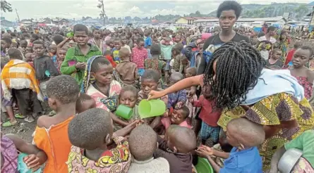 ?? /DJAFFAR SABITI / REUTERS ?? Internally displaced children wash hands as they wait to receive porridge from volunteers at Munigi camp near Goma in the North Kivu province of the Democratic Republic of Congo.