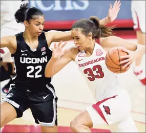  ?? Michael Woods / Associated Press ?? Arkansas’ Chelsea Dungee (33) tries to drive past UConn’s Evina Westbrook (22) on Thursday night in Fayettevil­le, Ark.