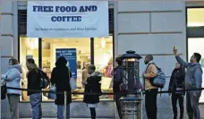  ?? ANDREW HARRER VIA GETTY IMAGES ?? Customers wait in line outside a restaurant opened for federal workers in Washington on Thursday.