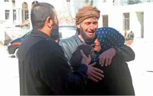  ??  ?? The relatives of Abdel Basset Al Satuf stand next to an ambulance in Al Hbeit as he’s being transferre­d to Turkey for medical treatment. —