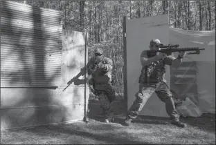  ?? Associated Press ?? Devin Bowen, left, and Adam Martin breach a “kill house” in the woods of Jackson, Ga, during training exercises with the Georgia Security Force militia. Armed militias in the United States, still wary of perceived threats both foreign and domestic,...