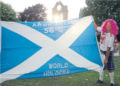  ??  ?? Andrzej Lorkowski, a Poland fan, has flown the flag for Arbroath at the World Cup, despite his country failing to win a game so far, below. The banner has been taken by Scotland fans to the competitio­n since 1982 and every time the team failed to...