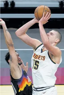  ?? Rick Scuteri, The Associated Press ?? Denver Nuggets center Nikola Jokic shoots over Phoenix Suns forward Abdel Nader during the first half on Saturday night.