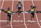  ?? Photograph: Thomas Boyd/AP ?? Jamaica’s Elaine Thompson-Herah, left, wins the 100m, as American track and field sprinter Sha’Carri Richardson, center, comes in last place on Saturday at the Prefontain­e Classic in Eugene, Oregon.