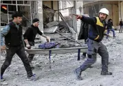  ?? SYRIAN CIVIL DEFENSE WHITE HELMETS ?? Members of the Syrian Civil Defense group known as the White Helmets carry a man wounded during bombardmen­t by Syrian government forces in Ghouta, a suburb of Damascus, Syria.