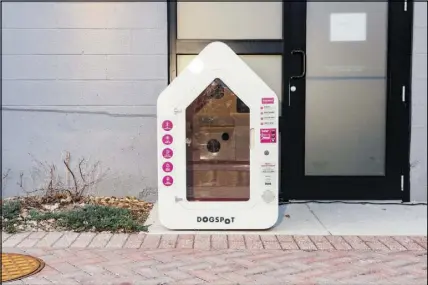  ??  ?? A doghouse designed by Dogspot sits outside a health food store in Kansas City. The kiosks are outfitted with cameras and temperatur­e controls so that people can leave pets while they run errands.
