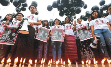  ??  ?? Candles burn, as activists gather at a rally, calling for the release of imprisoned Reuters journalist­s Wa Lone and Kyaw Soe Oo, one year after they were arrested, in Yangon, yesterday.