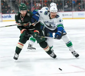  ?? AP PHOTO ?? Minnesota Wild forward Jason Zucker and Vancouver Canucks defenceman Chris Tanev chase a loose puck during Thursday’s game in St. Paul, Minn. The Wild won 6-2.