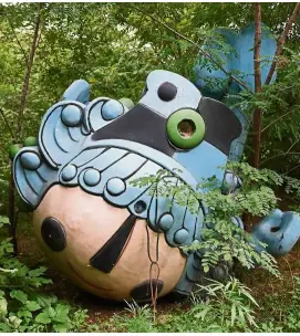  ??  ?? Beibei, one of five mascots for the 2008 Beijing Olympic Games, lying amongst trees behind an abandoned, never-completed mall in Beijing.