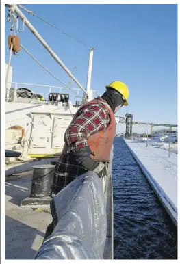  ?? Laura Pedersen / National Post ?? MV Kaministiq­ua second mate Conrad Seymour works the winch as the bulk carrier enters a series of locks in the Welland Canal, which connects Lake Erie to Lake Ontario.