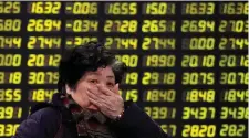  ??  ?? An investor outside a Shanghai brokerage house yesterday as Chinese shares sank 4pc in the latest shock in a week of turmoil