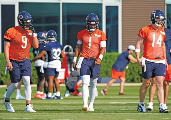  ?? NAM Y. HUH/AP ?? Fields (center), who will begin the regular season as the Bears’ No. 2 quarterbac­k, has two good mentors in veterans Andy Dalton (right) and Nick Foles. Dalton has been impressed with Fields’ speed.