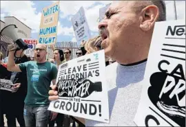  ?? Irfan Khan
Los Angeles Times ?? GEORGE MALDONADO, right, and others led by Courage Campaign rally in May in front of Nestle plants in L.A. demanding a halt to bottling operations.