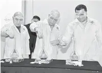  ??  ?? KELAI BEJADI: Manyin(tengah) ngemujur proses reaksyen kimia, nyadi simbolik bejadi‘Asasi Unimas Scienceplo­ration Camp 2018’ di Samarahan kemari. Bela dipeda Wan Hshim(kanan).