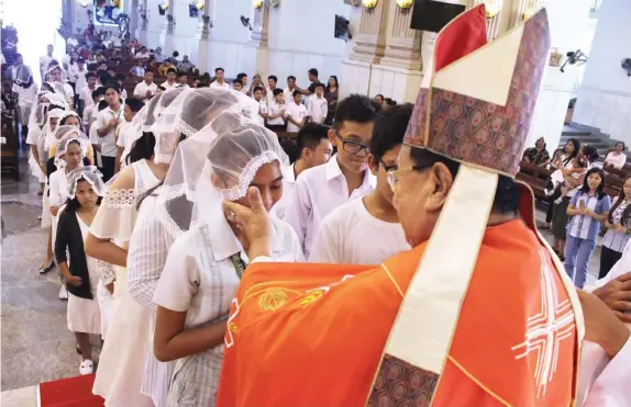  ?? TRISTAN LAPUT, USJ-R INTERN ?? Hundreds of children receive the Sacrament of Confirmati­on from Msgr. Esteban Binghay during a rite sponsored by the Jose R. Gullas Halad Foundation at the Cebu Metropolit­an Cathedral.
