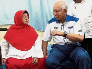  ??  ?? Najib speaking with Fatimah about her health at Kampung Baru Salong in Pekan. — Bernama Ever loyal: