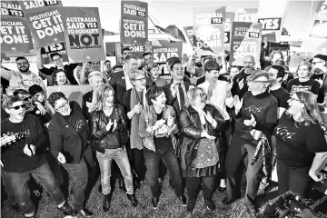  ??  ?? Equality ambassador­s and volunteers from the Equality Campaign celebrate as they gather in front of Parliament House in Canberra. — AFP photo