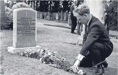  ??  ?? Ian Robertson placing flowers on the grave of the little boy, or “Unknown Bairn”, he found washed up on the beach at Tayport in 1971.