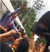  ?? PNA FOTO ?? VIGIL. Former senator Ferdinand Marcos Jr. waves to supporters who kept vigil in front of the Supreme Court, while the justices held the preliminar­y conference on Marcos’s election protest.