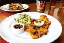  ?? ?? Schnitzel with a potato cucumber salad and a side of Lingonberr­y jam is one of Leopold’s many Austrian-inspired dishes.