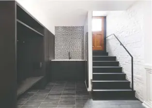  ?? The Moroccan-style tile in this vestibule/mudroom is a visual focal point, the minimalist black stairs and black cabinets leading the eye to the detailed black-and-white tiles above the sink. ??