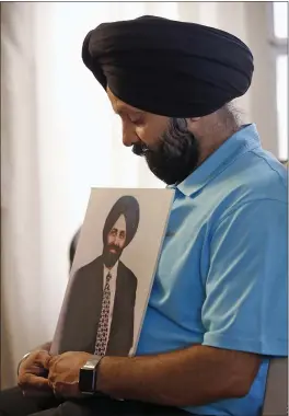  ?? ROSS D. FRANKLIN — THE ASSOCIATED PRESS ?? Rana Singh Sodhi holds a photograph of his murdered brother, Balbir Singh Sodhi, in Gilbert, Ariz.