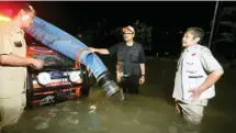  ?? BOY SLAMET/JAWA POS ?? TINGGIKAN JALUR: Petugas melakukan peninggian jalur kereta di Porong, Sidoarjo, kemarin. Foto kanan, Wagub Jatim Saifullah Yusuf meninjau banjir di Raya Porong.