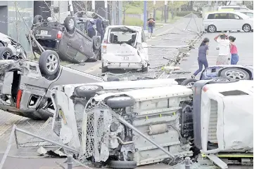  ?? — Reuters photo ?? Vehicles damaged by the typhoon are seen in Osaka, western Japan, in this photo taken by Kyodo.