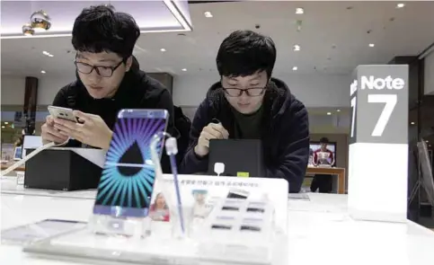  ?? —AP ?? SEOUL: In this Monday, Oct. 10, 2016, file photo, South Korean high school students try out Samsung Electronic­s Galaxy Note 7 smartphone­s at the company’s shop.